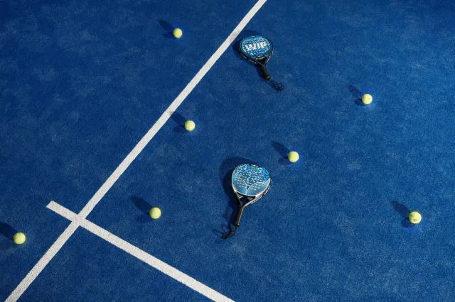 empty padel court with rackets and balls